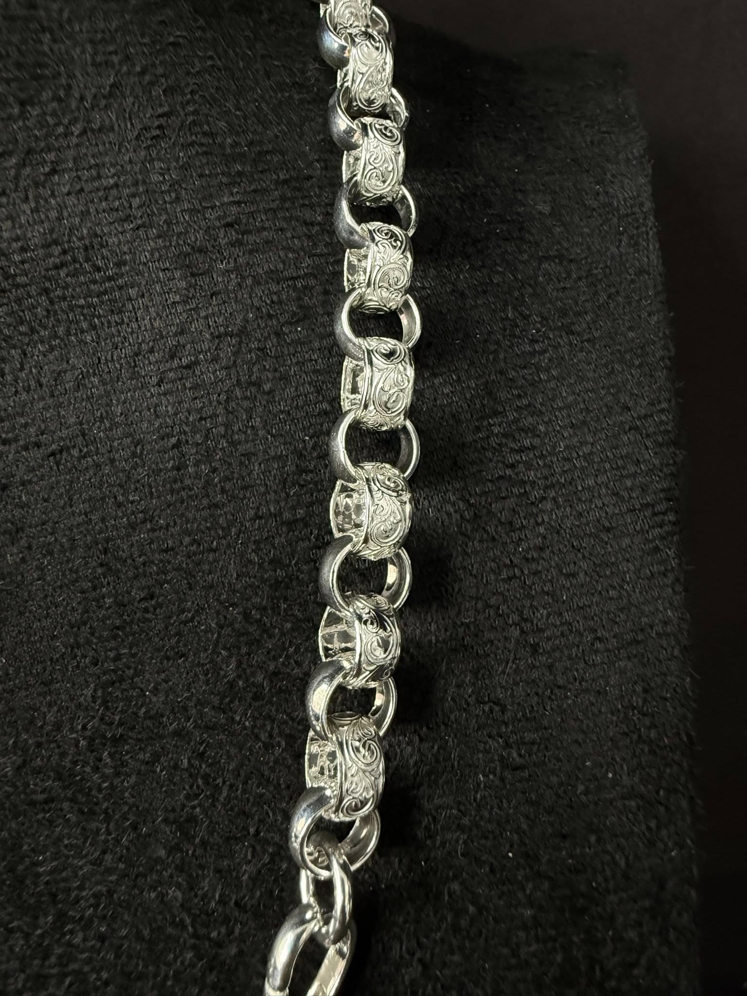 Silver chain necklace on a black textured background