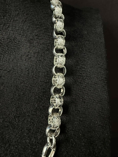Silver chain necklace on a black textured background